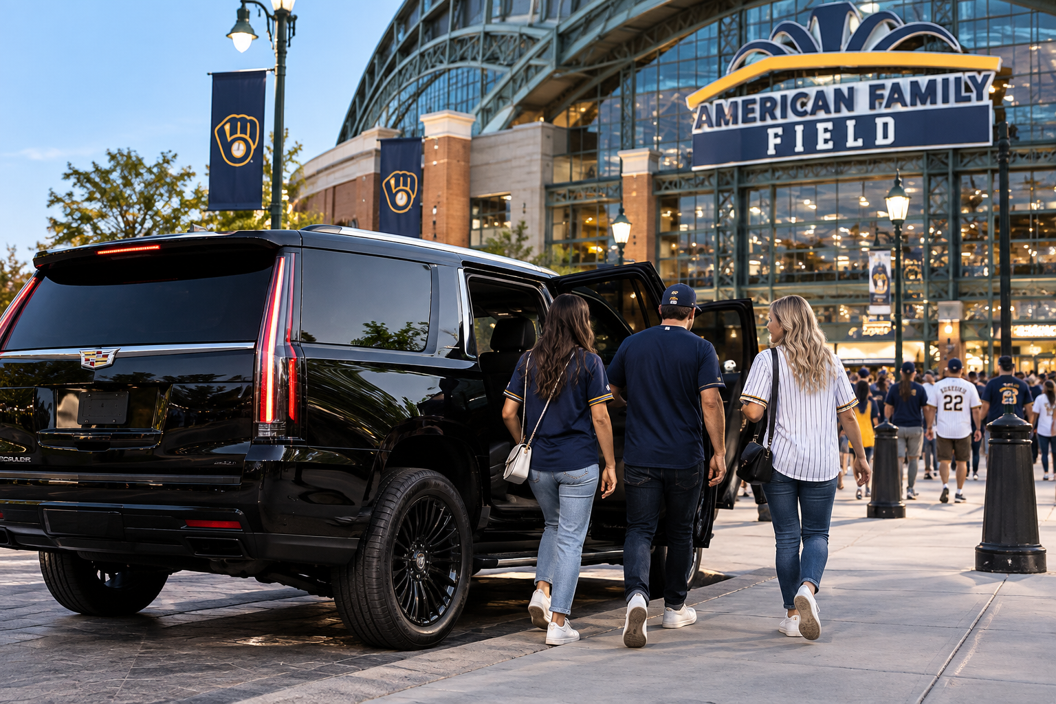 Black Cadillac Escalade dropping off three passengers at American Family Field in Milwaukee for a Brewers baseball game.